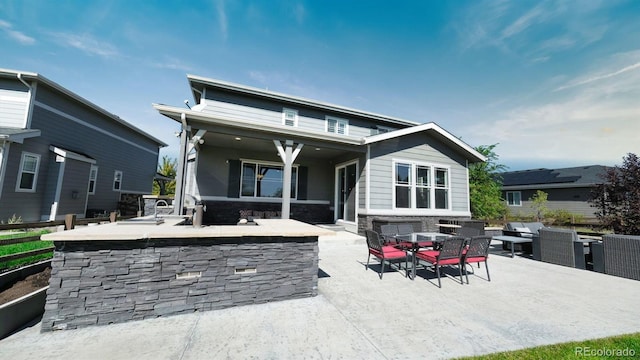 rear view of property featuring a bar and a patio area