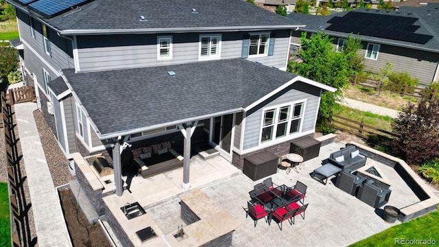 rear view of property with an outdoor living space with a fire pit and a patio area