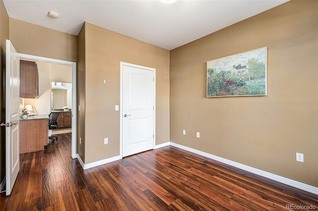 10184 Park Meadows Dr Unit 1102, Lone Tree, CO 80124 - unfurnished bedroom featuring dark wood-style floors, baseboards, and an office area