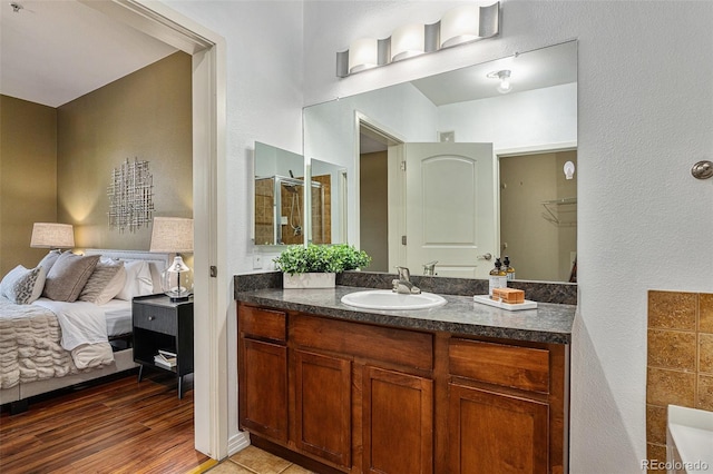 10184 Park Meadows Dr Unit 1102, Lone Tree, CO 80124 - ensuite bathroom featuring vanity, a textured wall, and wood finished floors