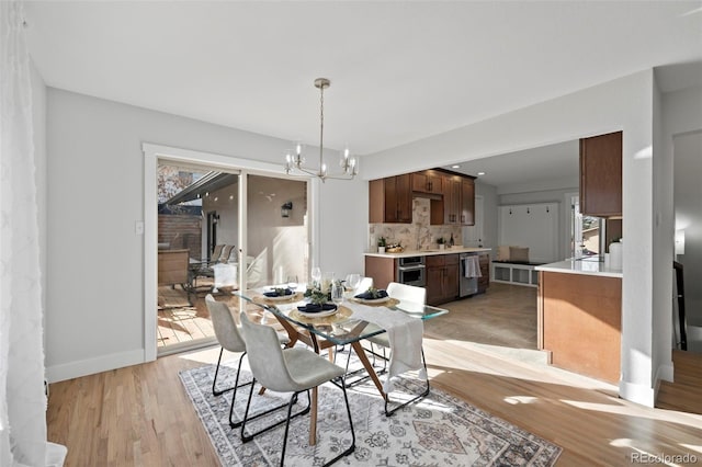 dining space featuring a wealth of natural light, an inviting chandelier, and light wood-type flooring