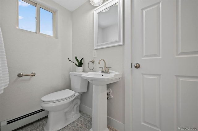 bathroom featuring sink, toilet, and baseboard heating