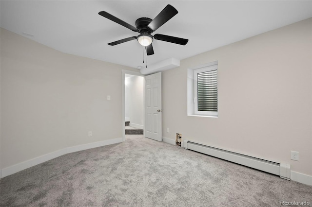 spare room with light colored carpet, ceiling fan, and a baseboard heating unit