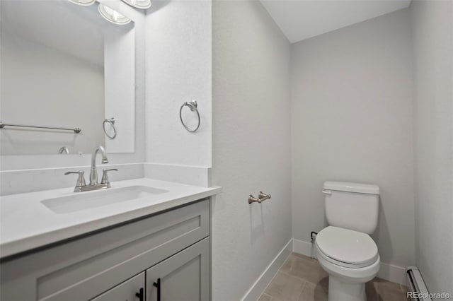 bathroom featuring tile patterned flooring, vanity, toilet, and a baseboard heating unit