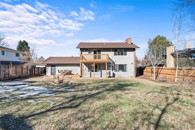 rear view of house with a lawn and a balcony