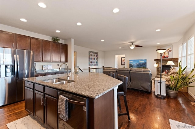 kitchen with a center island with sink, sink, dark hardwood / wood-style floors, stainless steel fridge, and dark brown cabinetry