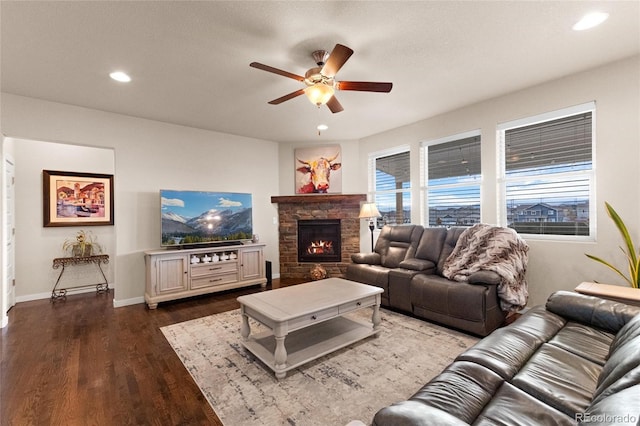 living room with hardwood / wood-style floors, ceiling fan, and a fireplace