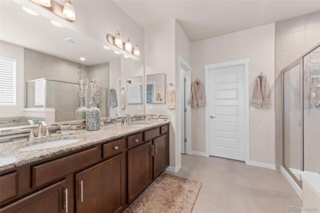 bathroom featuring tile patterned floors, a shower with door, and vanity