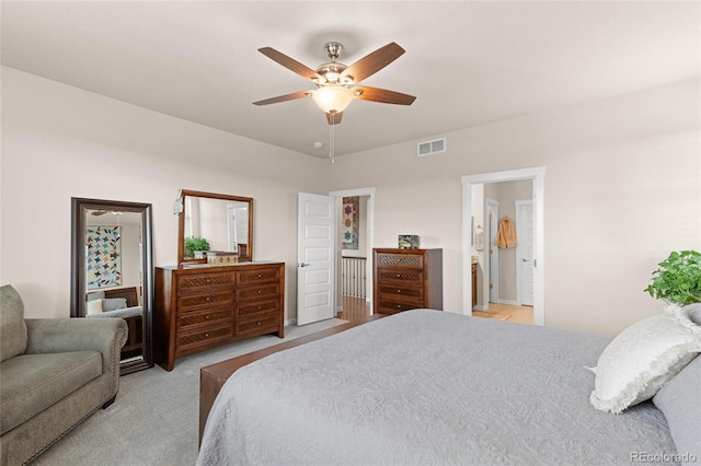 bedroom featuring connected bathroom, ceiling fan, and light carpet