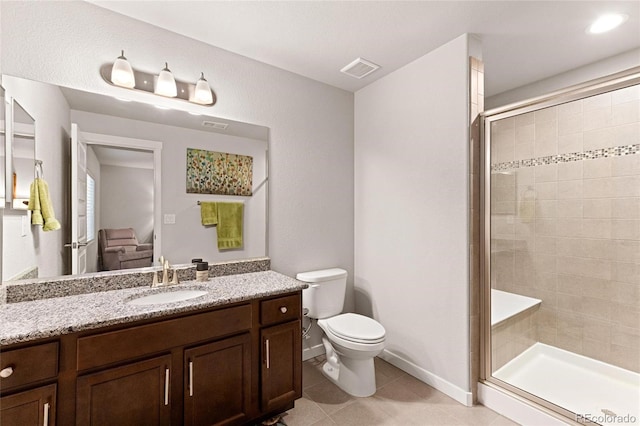 bathroom featuring tile patterned floors, vanity, toilet, and a shower with shower door