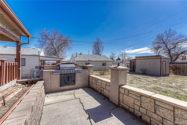 view of patio / terrace featuring a storage unit, an outdoor structure, and fence