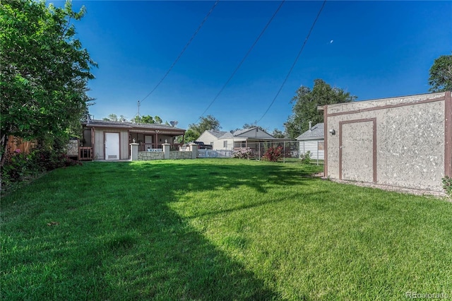 view of yard featuring an outdoor structure and fence