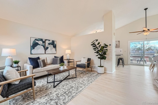 living area featuring high vaulted ceiling, a ceiling fan, baseboards, and wood finished floors