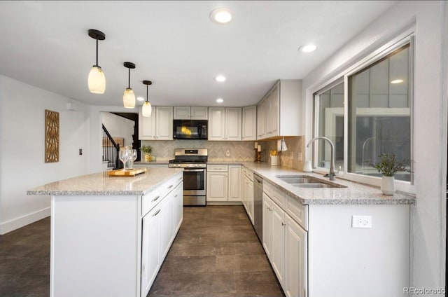 kitchen featuring sink, backsplash, stainless steel appliances, decorative light fixtures, and light stone counters