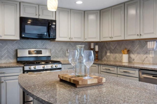 kitchen featuring backsplash, appliances with stainless steel finishes, gray cabinets, and a kitchen breakfast bar