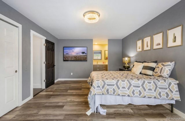 bedroom featuring connected bathroom and dark hardwood / wood-style flooring