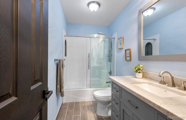 full bathroom with toilet, enclosed tub / shower combo, vanity, and hardwood / wood-style floors