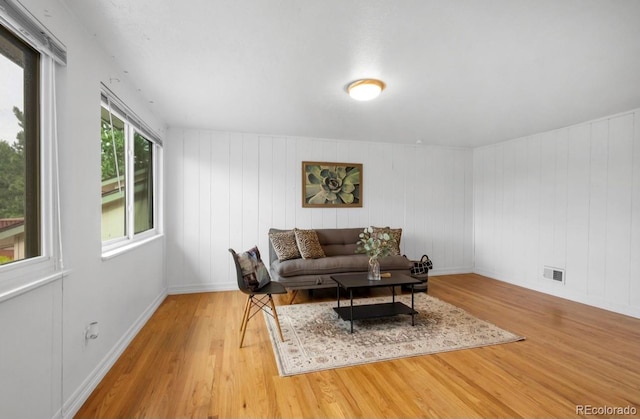 living room with wooden walls and hardwood / wood-style flooring