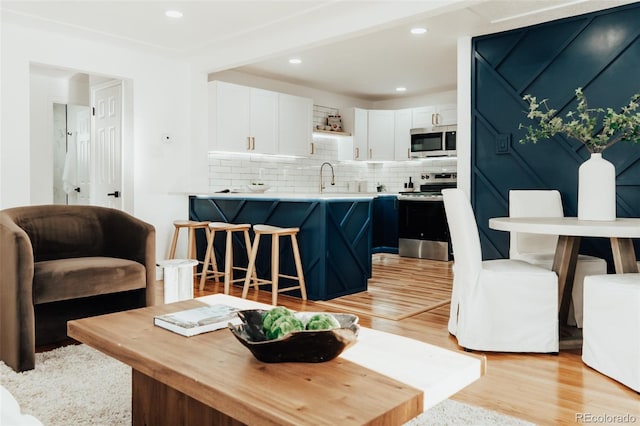 living area with light wood-style floors and recessed lighting