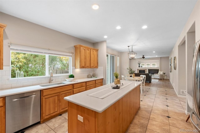 kitchen with sink, a kitchen island, pendant lighting, stainless steel dishwasher, and decorative backsplash