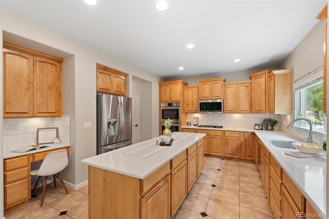 kitchen featuring sink, a center island, light tile patterned flooring, appliances with stainless steel finishes, and tasteful backsplash