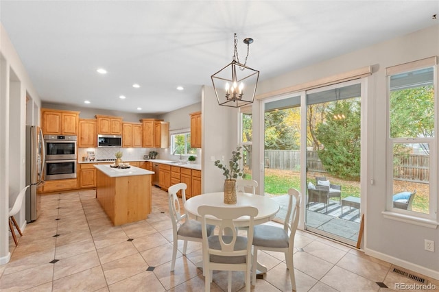 kitchen featuring a wealth of natural light, pendant lighting, a center island, and stainless steel appliances