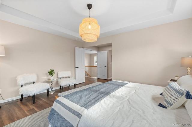 bedroom featuring a tray ceiling and dark hardwood / wood-style flooring