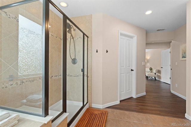 bathroom with hardwood / wood-style flooring and an enclosed shower