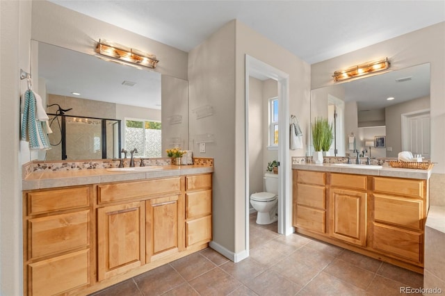 bathroom with vanity, a shower with shower door, toilet, and tile patterned floors