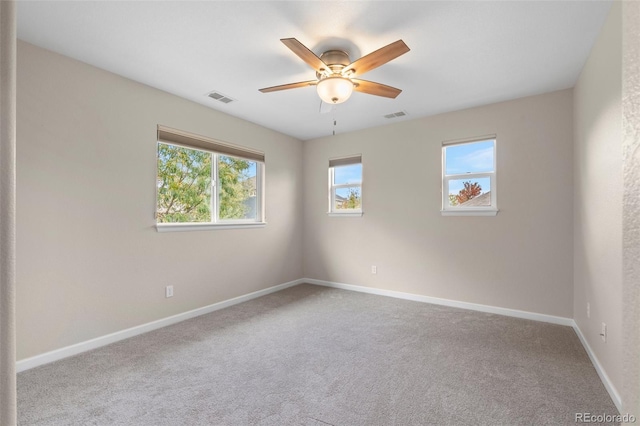 carpeted spare room featuring ceiling fan