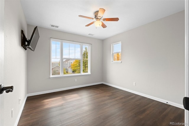 spare room with dark wood-type flooring and ceiling fan