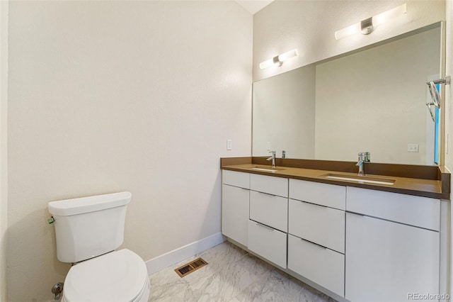 bathroom with marble finish floor, double vanity, a sink, and visible vents