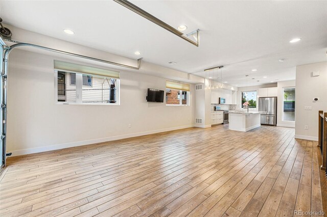 unfurnished living room with visible vents, recessed lighting, light wood-style flooring, and baseboards