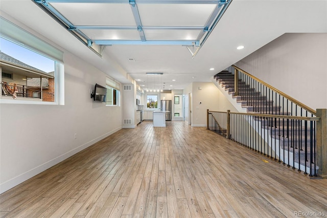 unfurnished living room featuring light wood-style flooring, visible vents, baseboards, and recessed lighting