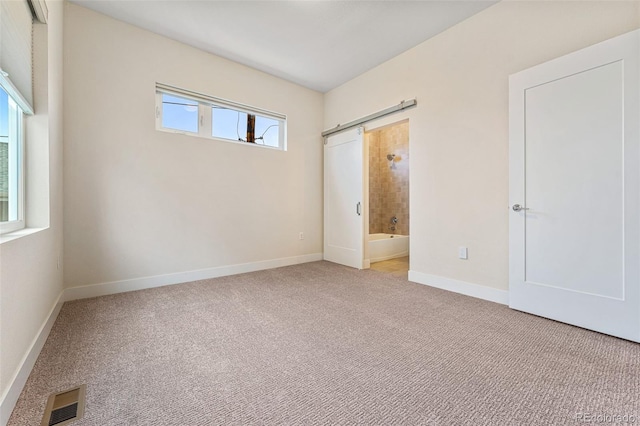 spare room with light colored carpet, visible vents, and baseboards