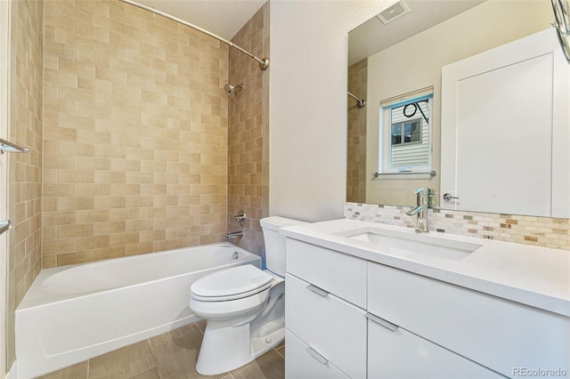 full bathroom featuring visible vents, decorative backsplash, toilet, vanity, and washtub / shower combination