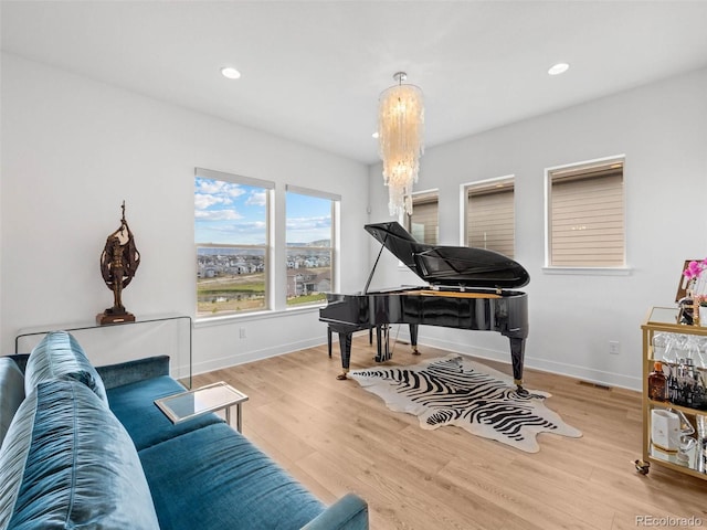 living area featuring a notable chandelier and light wood-type flooring