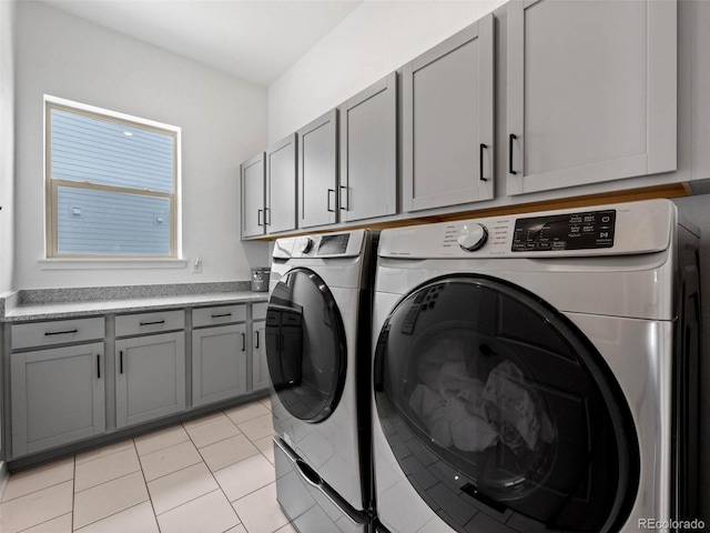 laundry room with cabinet space, washing machine and clothes dryer, and light tile patterned flooring