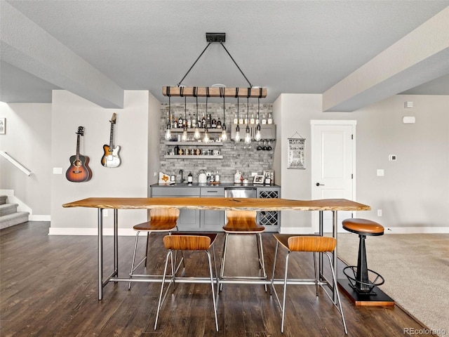 bar with dark wood-style flooring, baseboards, stairway, decorative backsplash, and indoor wet bar