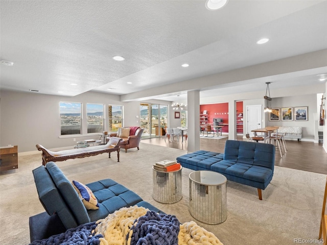 living area with baseboards, a textured ceiling, and recessed lighting