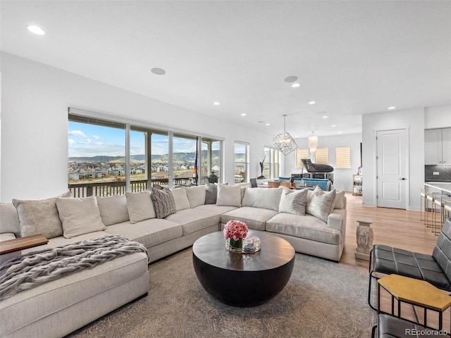 living area featuring light wood finished floors, a chandelier, and recessed lighting