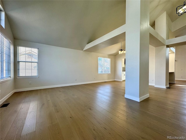 unfurnished living room featuring visible vents, a healthy amount of sunlight, and dark wood-style flooring