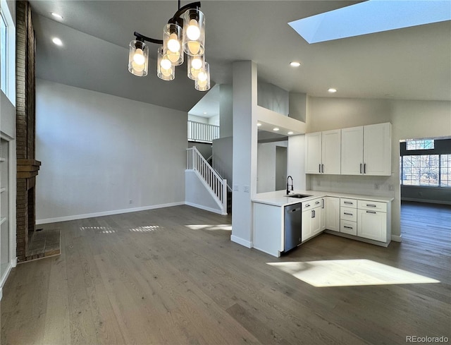 kitchen featuring dark wood-style floors, white cabinetry, a fireplace, light countertops, and dishwasher