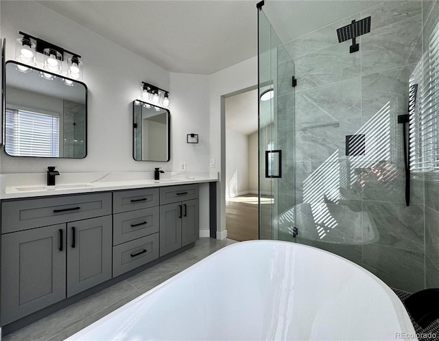 bathroom with a soaking tub, double vanity, a stall shower, a sink, and marble finish floor