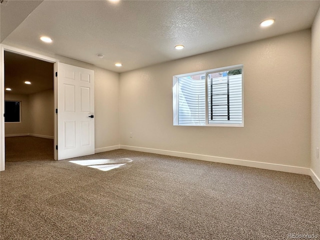 carpeted empty room with recessed lighting, a textured ceiling, and baseboards