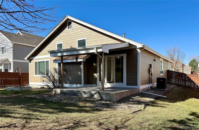 rear view of house featuring central AC unit, a patio area, a yard, and fence