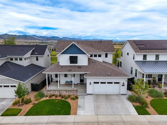 view of front of house featuring covered porch, a mountain view, and a garage