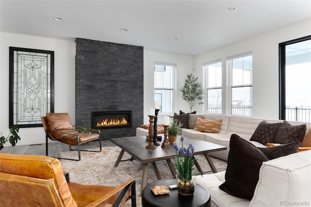 living room featuring light hardwood / wood-style flooring and a stone fireplace