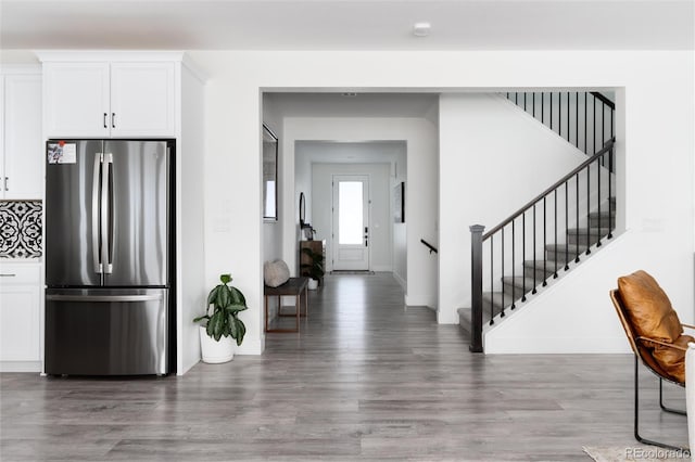 kitchen with white cabinetry, decorative backsplash, stainless steel fridge, and dark hardwood / wood-style flooring