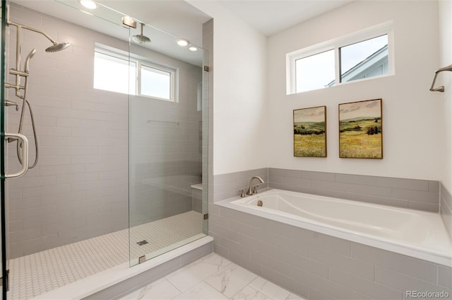 bathroom featuring a healthy amount of sunlight and independent shower and bath